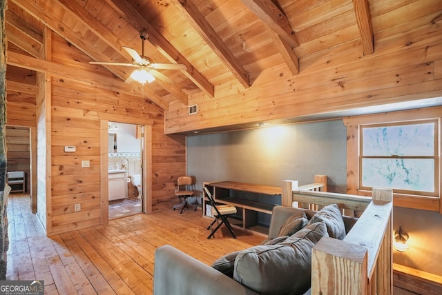 living area featuring wood ceiling, vaulted ceiling with beams, wood walls, and light wood finished floors