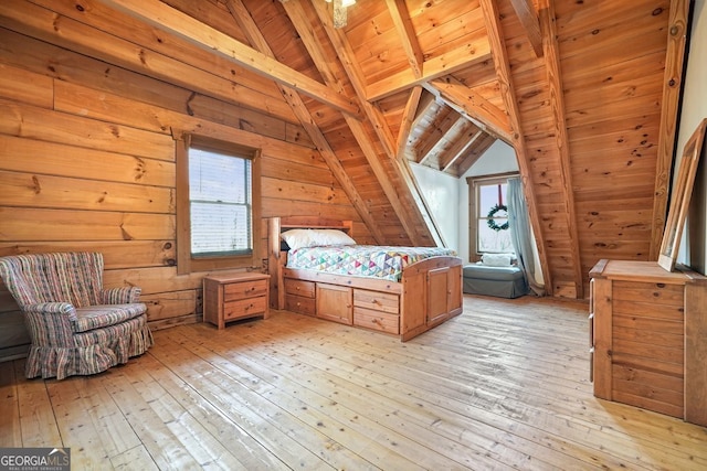 unfurnished bedroom featuring vaulted ceiling with beams, multiple windows, and light wood-type flooring