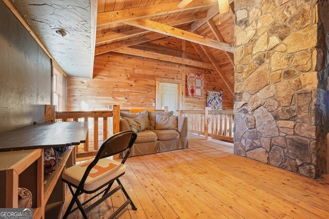 interior space featuring vaulted ceiling with beams, light hardwood / wood-style floors, wooden walls, and wood ceiling