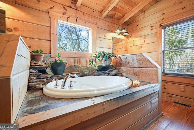 bathroom with wooden walls, visible vents, wood ceiling, wood finished floors, and vaulted ceiling with beams