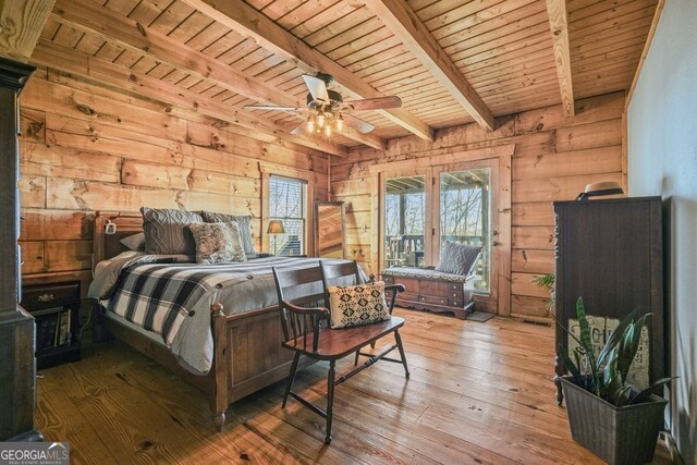 spacious closet featuring beamed ceiling, a workshop area, and wood finished floors