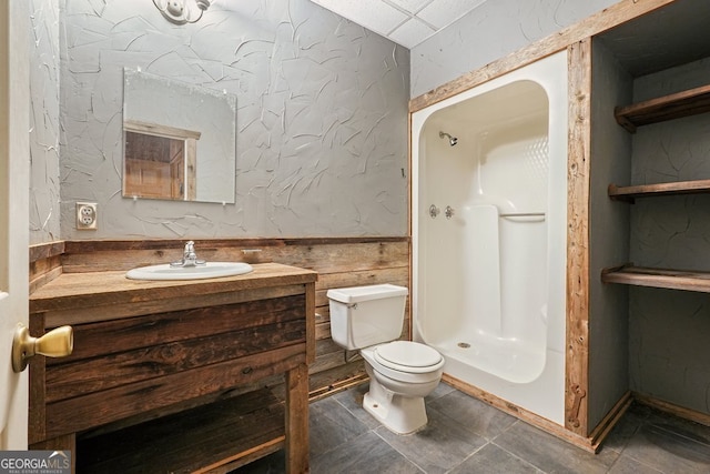 bathroom featuring a shower, tile patterned floors, vanity, and toilet