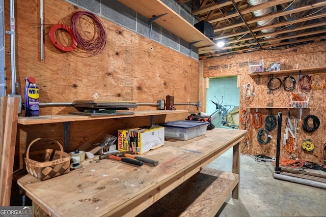 misc room featuring a workshop area and unfinished concrete floors