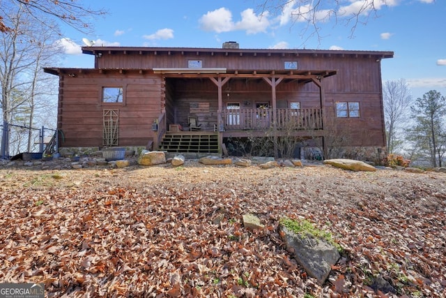 back of property featuring a deck and a chimney