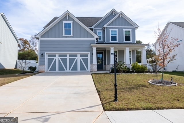 view of front facade with a porch, a garage, and a front lawn