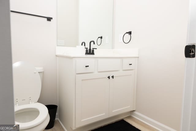 bathroom featuring hardwood / wood-style floors, vanity, and toilet