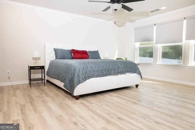 bedroom with light hardwood / wood-style flooring, ceiling fan, and crown molding