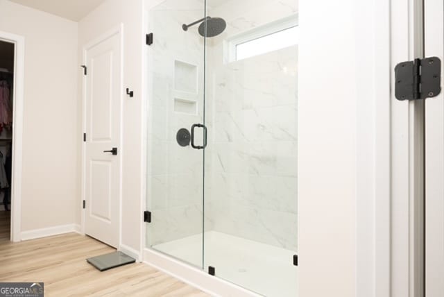 bathroom featuring hardwood / wood-style floors and an enclosed shower