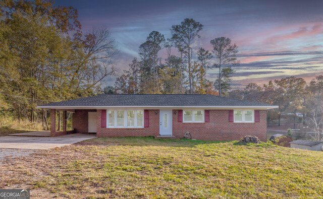 ranch-style house with a front lawn and a carport