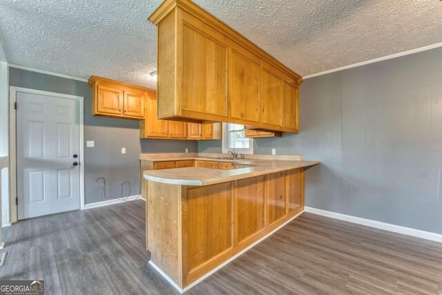 empty room featuring wood-type flooring, a textured ceiling, heating unit, and crown molding