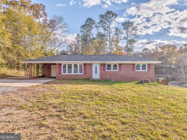 ranch-style home with a carport, brick siding, and a front lawn