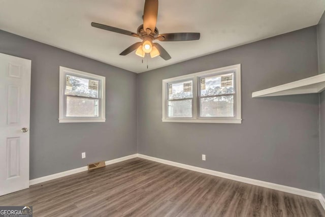 unfurnished room featuring ceiling fan and dark hardwood / wood-style flooring