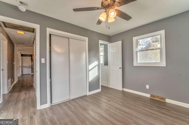 unfurnished bedroom with hardwood / wood-style floors, a closet, and ceiling fan