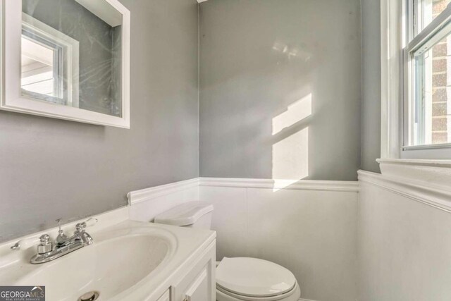 spare room featuring a textured ceiling, ceiling fan, a healthy amount of sunlight, and dark wood-type flooring