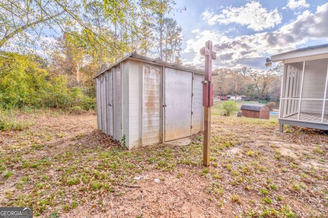 rear view of house featuring a sunroom and an outdoor structure