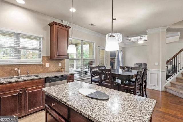 kitchen with stainless steel dishwasher, a healthy amount of sunlight, wood-type flooring, and sink