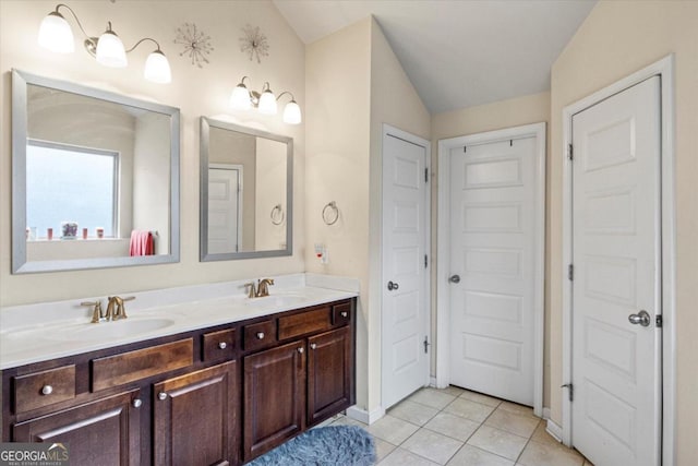 bathroom with tile patterned flooring, vanity, and lofted ceiling