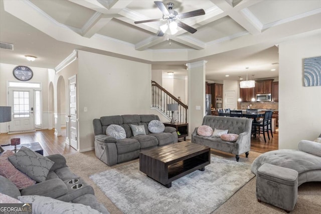 living room featuring crown molding, ceiling fan, light hardwood / wood-style floors, and coffered ceiling