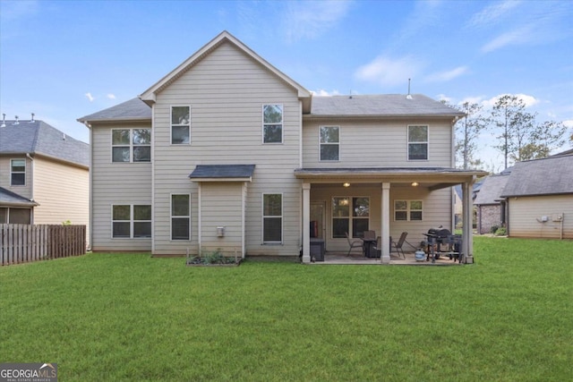 rear view of property with a yard and a patio