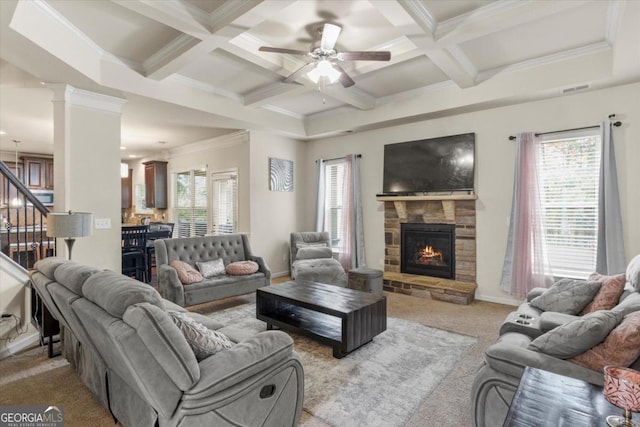 living room featuring light carpet, ornamental molding, coffered ceiling, ceiling fan, and a fireplace