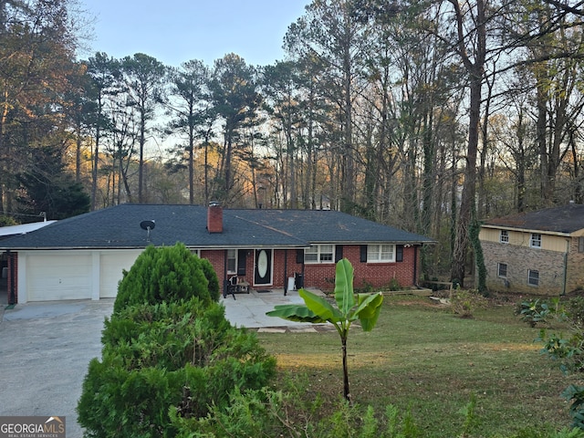 single story home with a garage and a front lawn