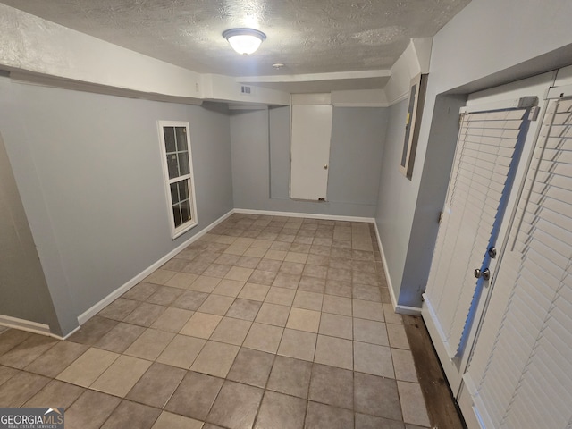 tiled spare room with a textured ceiling