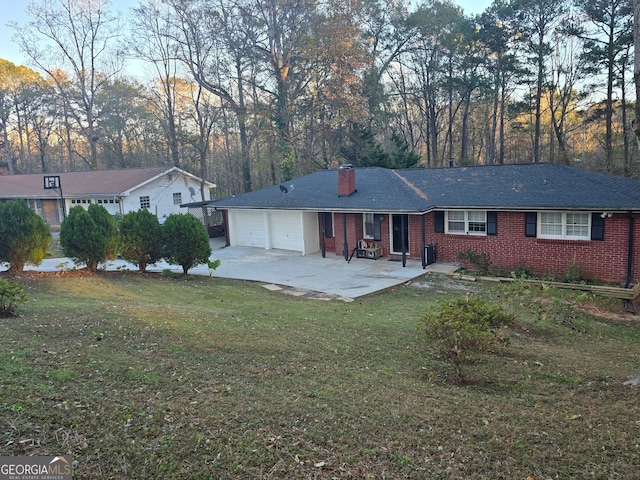 rear view of house with a lawn and a garage