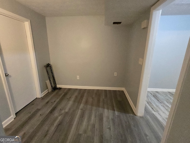 spare room with dark hardwood / wood-style flooring and a textured ceiling