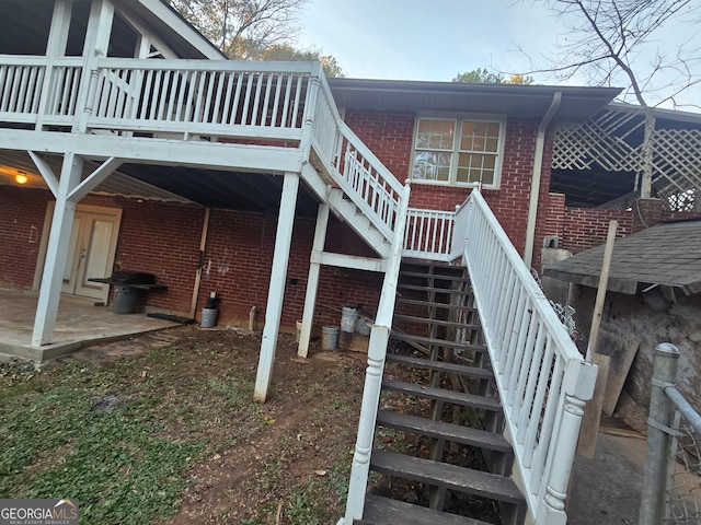 view of property exterior featuring a patio area and a wooden deck