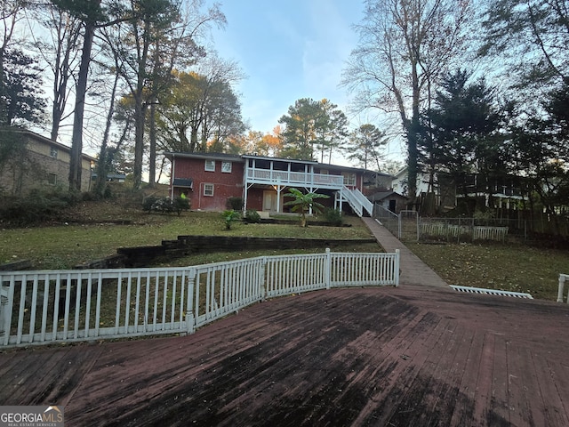 wooden deck featuring a lawn and a sunroom