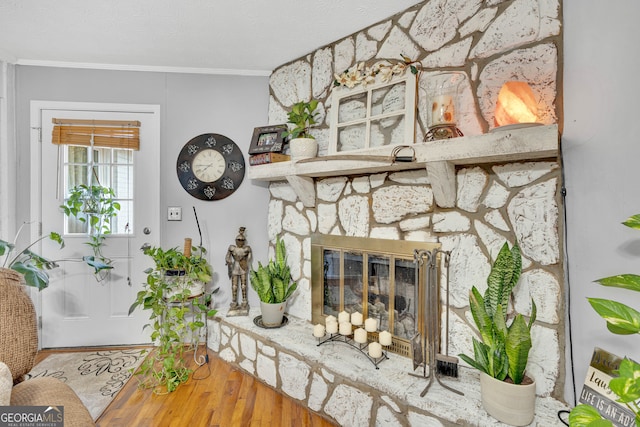 living room with a fireplace, hardwood / wood-style flooring, and crown molding