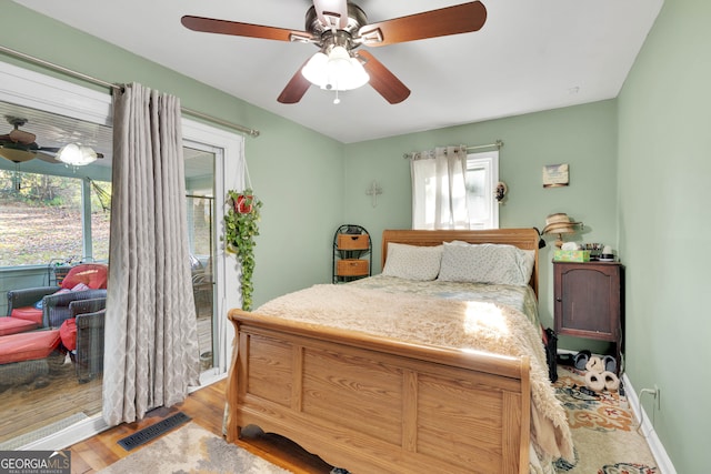 bedroom with light hardwood / wood-style flooring, multiple windows, and ceiling fan