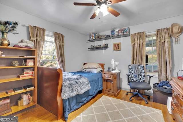 bedroom with multiple windows, ceiling fan, and light hardwood / wood-style flooring