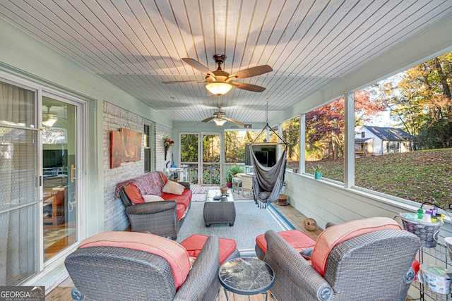 sunroom with ceiling fan, a healthy amount of sunlight, and wooden ceiling