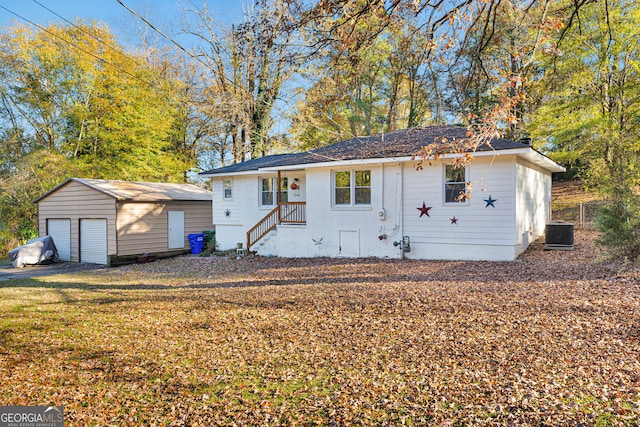 view of front of home featuring an outdoor structure, a front yard, and central AC