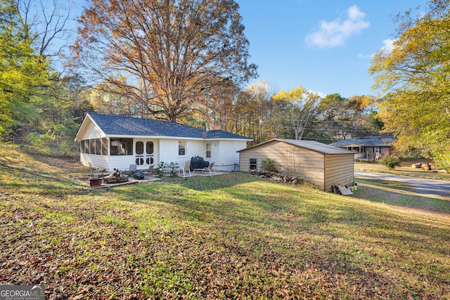 back of house with a lawn, a patio area, and a sunroom