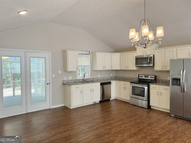 kitchen with sink, dark hardwood / wood-style floors, lofted ceiling, decorative light fixtures, and appliances with stainless steel finishes