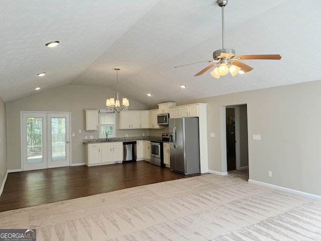 kitchen with lofted ceiling, wood-type flooring, sink, white cabinetry, and stainless steel appliances