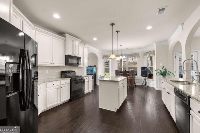 kitchen featuring white cabinets, sink, decorative light fixtures, and black appliances