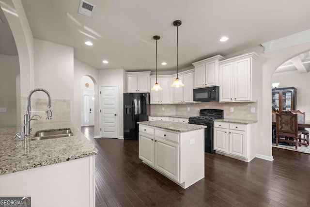 kitchen featuring black appliances, decorative light fixtures, white cabinetry, and sink