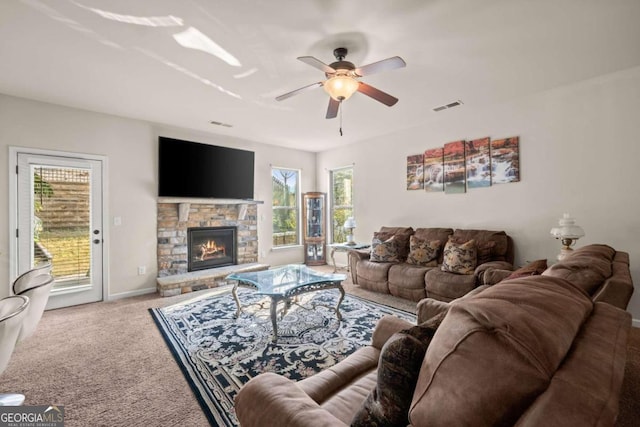 living room featuring carpet flooring, ceiling fan, plenty of natural light, and a fireplace