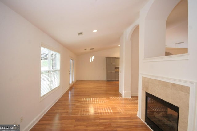 corridor featuring a chandelier, light wood-type flooring, and vaulted ceiling