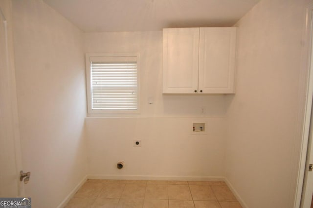 laundry area featuring electric dryer hookup, hookup for a washing machine, light tile patterned floors, and cabinets