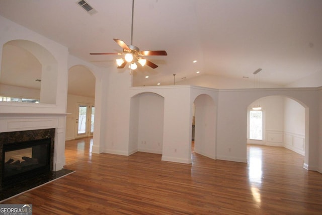 unfurnished living room with a fireplace, a wealth of natural light, hardwood / wood-style floors, and ceiling fan