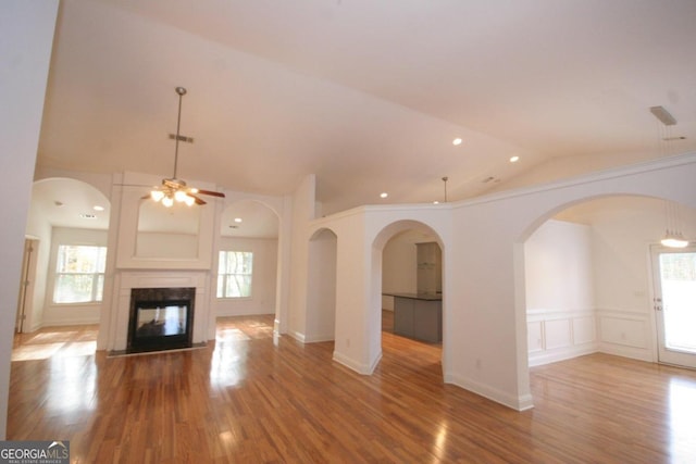 unfurnished living room featuring hardwood / wood-style flooring, plenty of natural light, and lofted ceiling