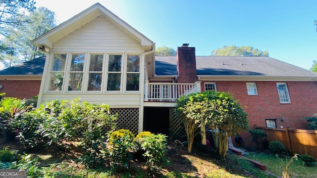 back of house with a wooden deck and a sunroom