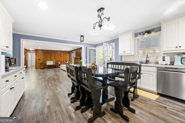 dining area featuring plenty of natural light, light hardwood / wood-style floors, ornamental molding, and sink