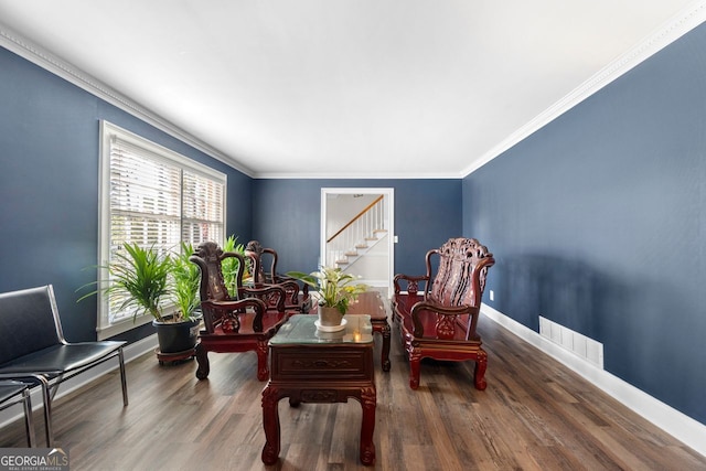 living area featuring wood-type flooring and ornamental molding