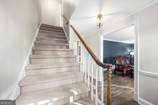 staircase with wood-type flooring and ornamental molding