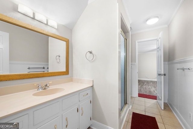 bathroom with tile patterned floors, vanity, a shower with door, and crown molding